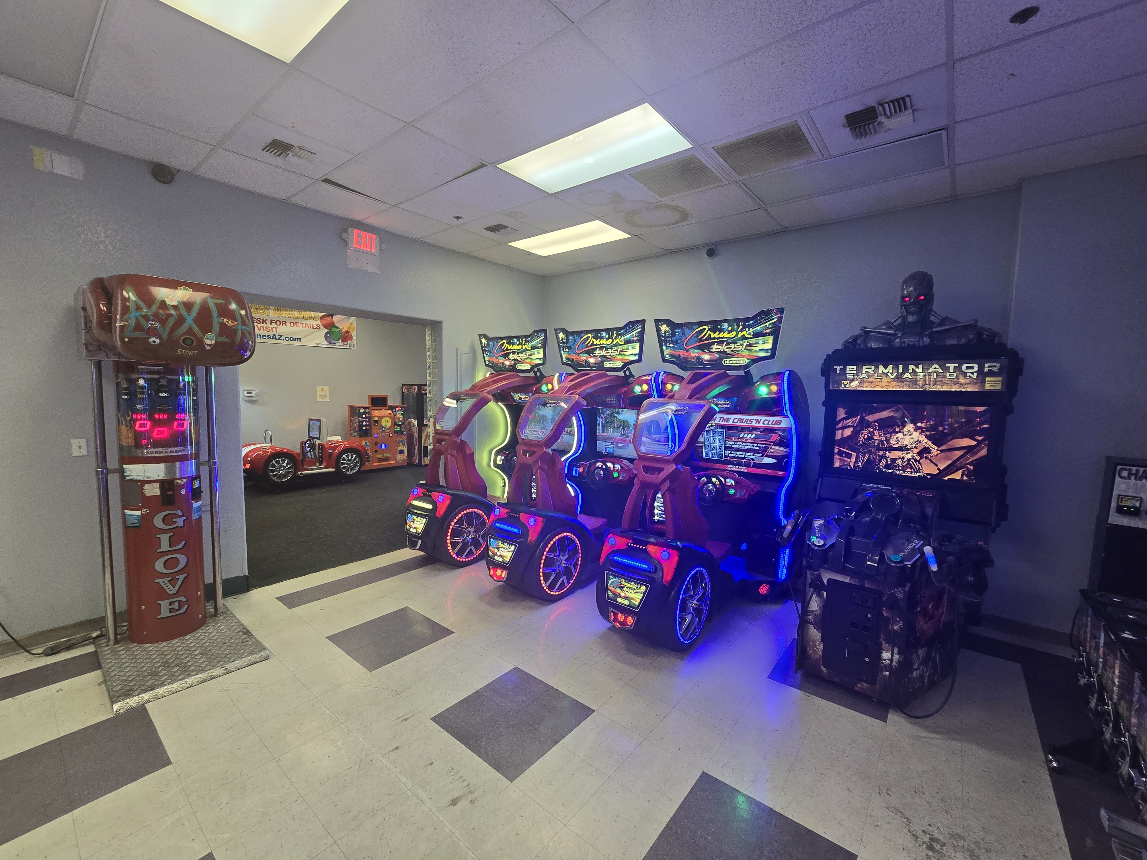 An arcade room with several racing and shooting video games, including Cruis'n Blast and Terminator Salvation, and a boxing game.