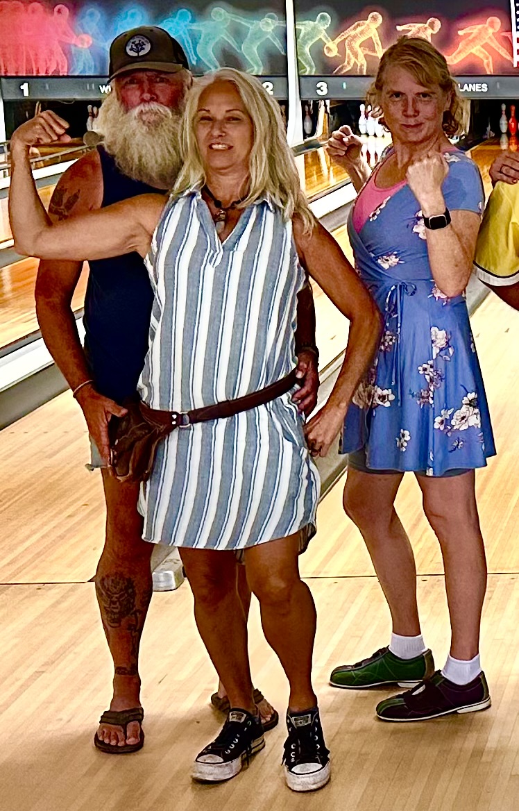 Three people posing and flexing their muscles on a bowling lane at Willamette Lanes.