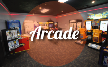 Arcade room at a bowling center with claw machines and video games under red accent lighting.