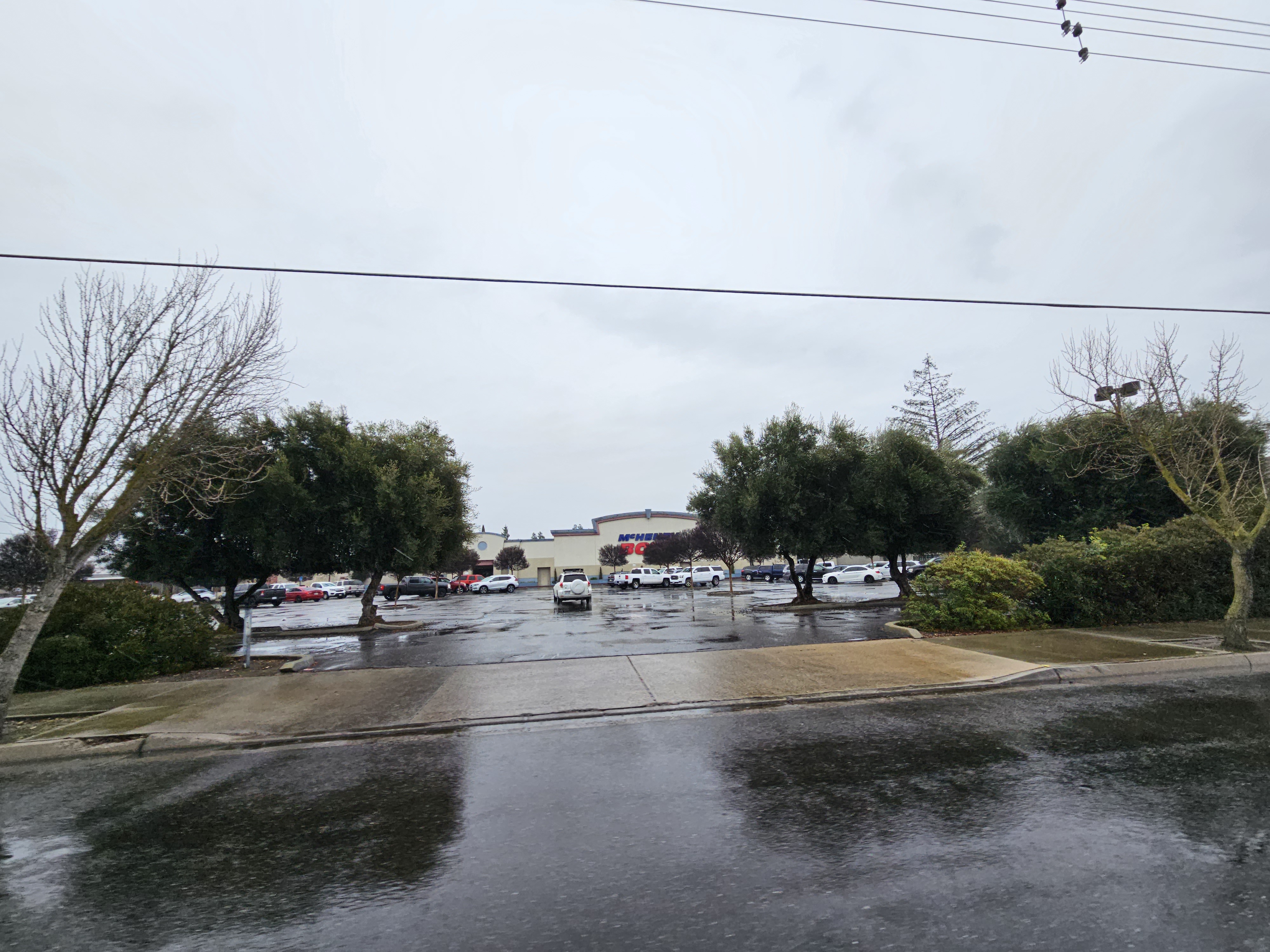 Exterior view of McHenry Bowl and its parking lot on a rainy day with overcast skies.