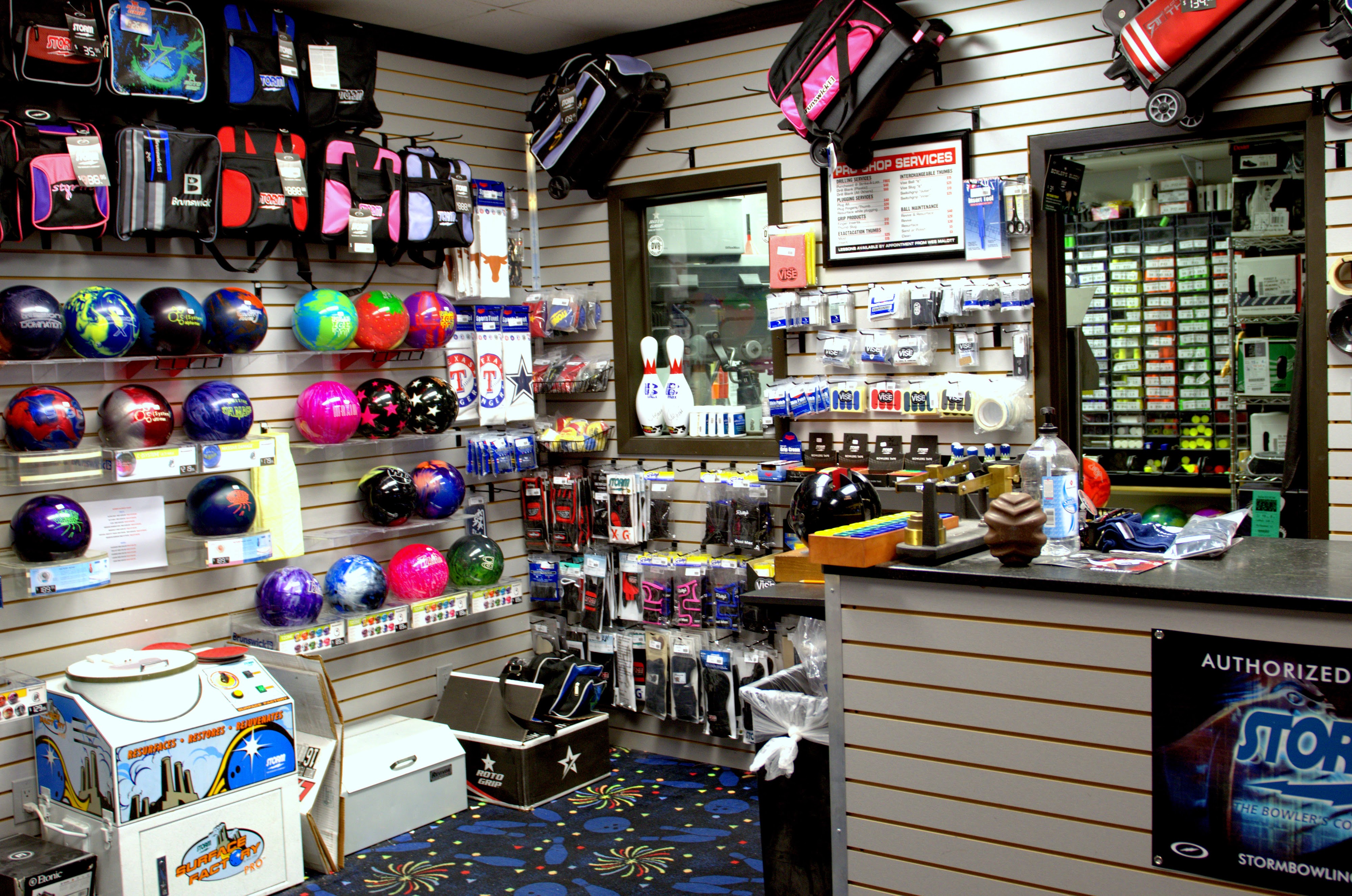 A bowling pro shop with walls of bowling balls, bags, accessories, and a technical service counter.
