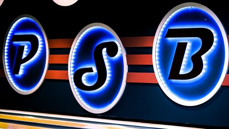 Three glowing oval signs on a dark wall spelling out the letters P, S, and B in bright blue light.