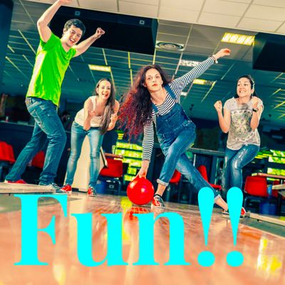 Four young adults bowling, with one woman releasing a red bowling ball down a lane.