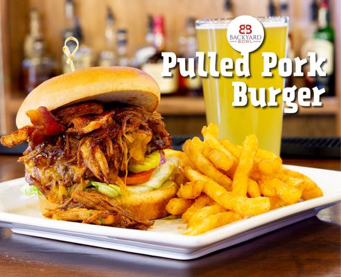 A pulled pork burger with bacon and fries served next to a pint of beer at Backyard Bowl.