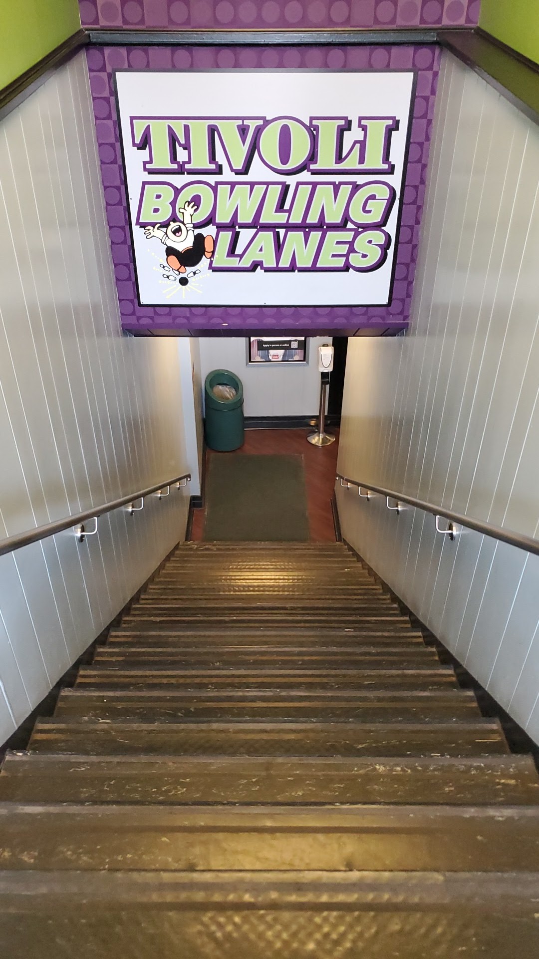 A staircase leading down into the center under a large Tivoli Bowling Lanes sign.