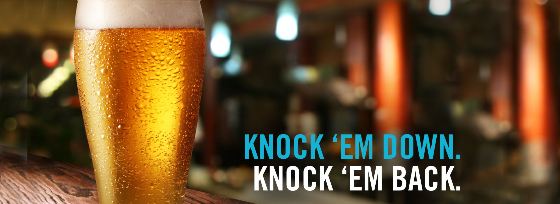 A cold, condensation-covered glass of beer next to the text 'Knock em down. Knock em back.'