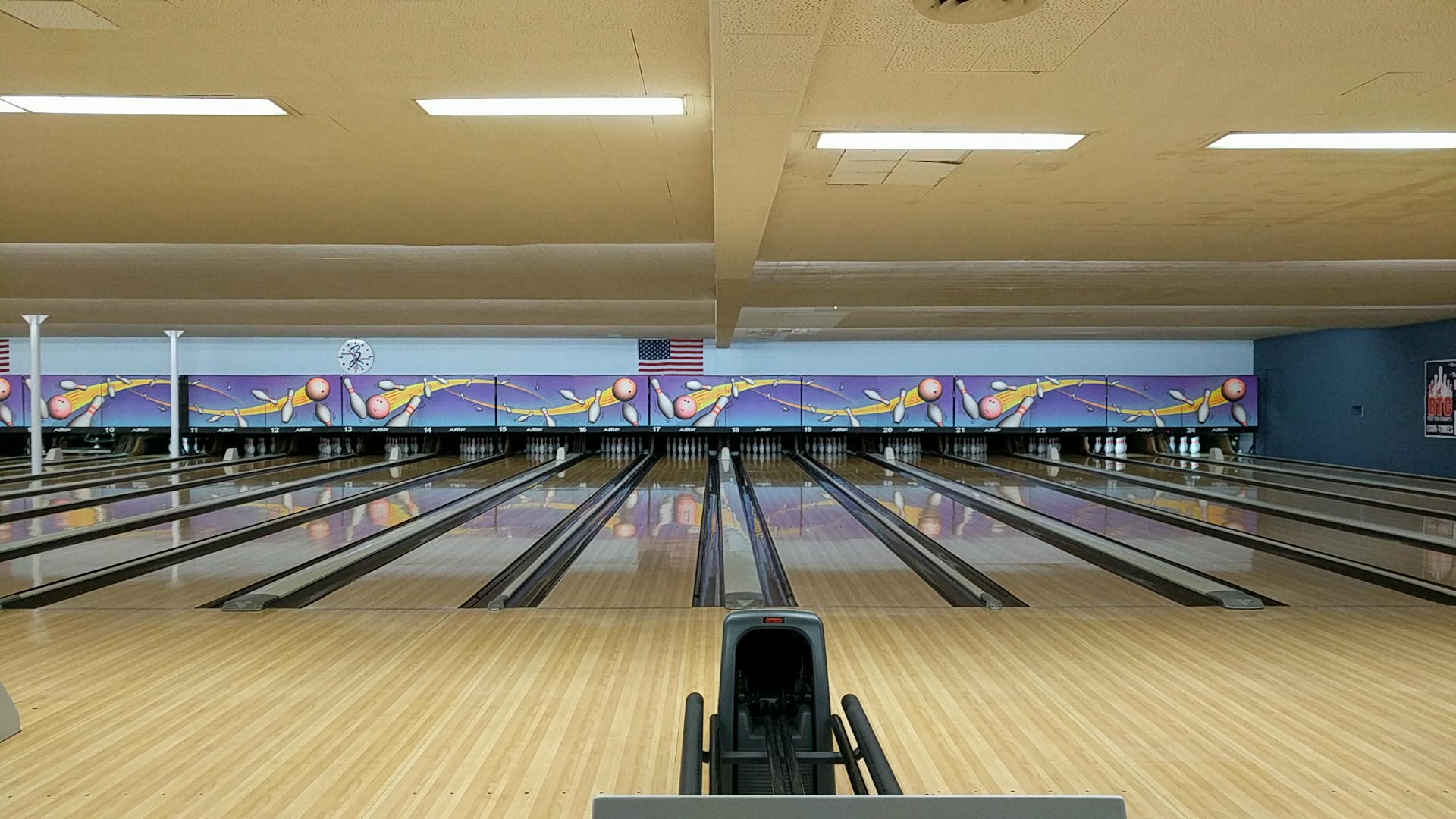 A clean, wide-angle view of multiple polished bowling lanes at Beverly Lanes with colorful masking units.