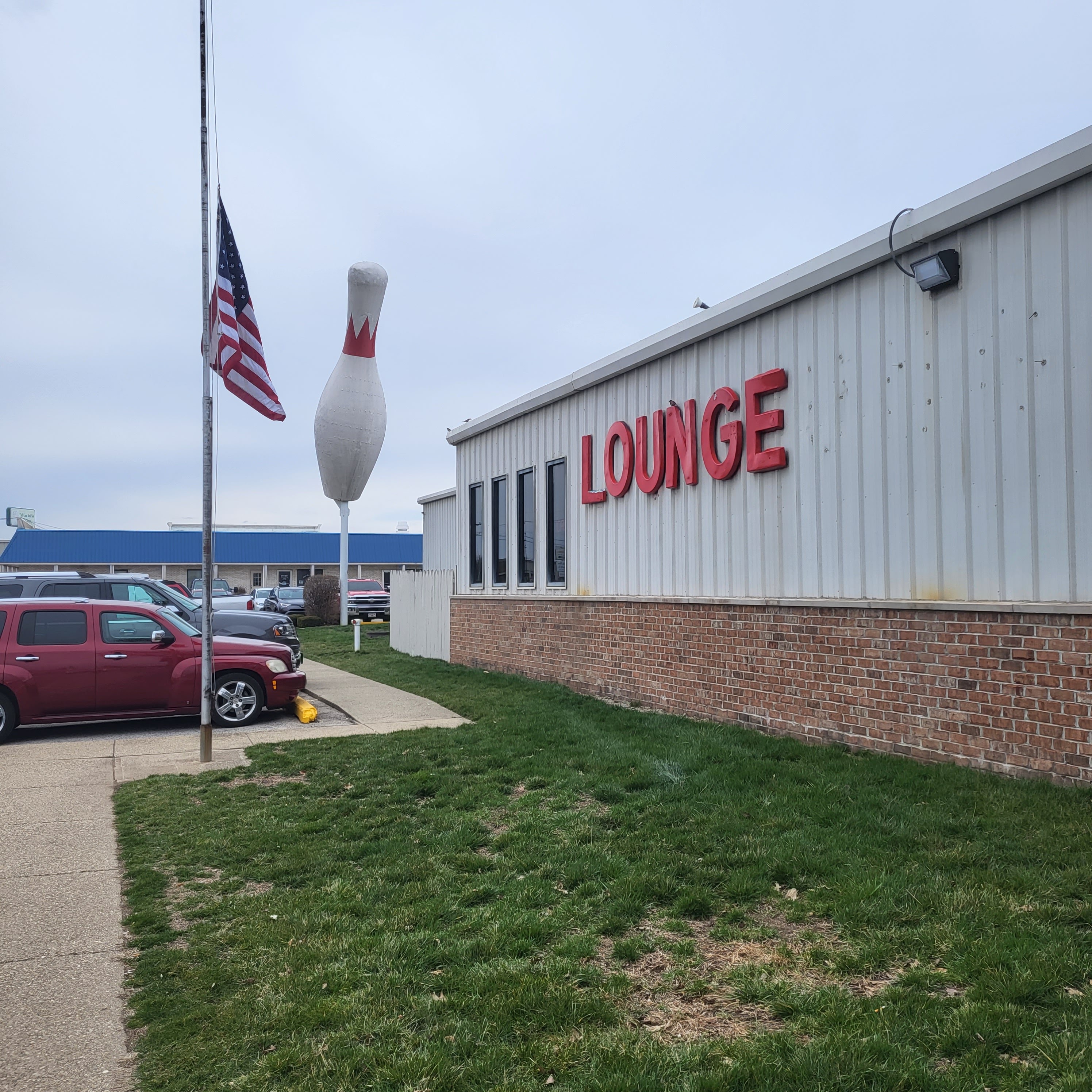 Exterior of Terre Haute Bowling Center with a giant bowling pin statue and a red Lounge sign on the building.