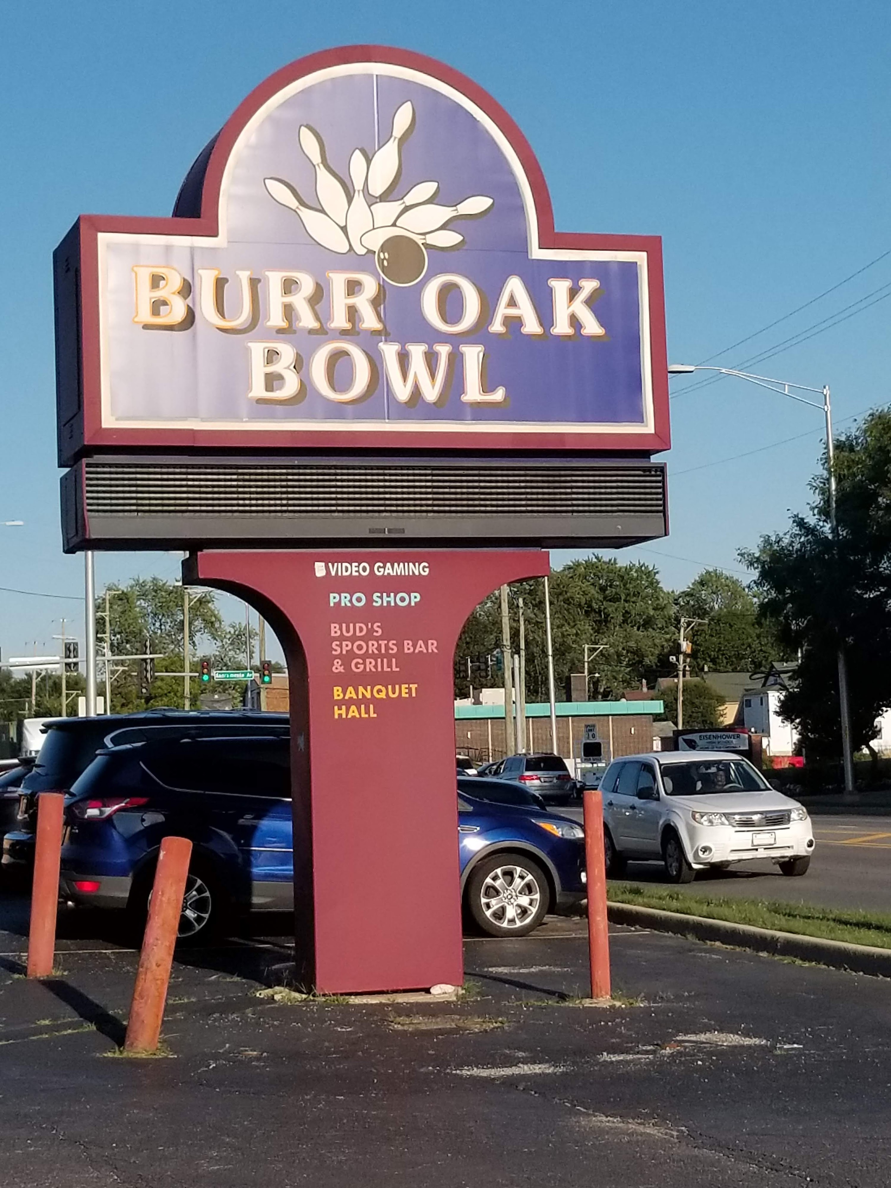 A large maroon and blue Burr Oak Bowl pylon sign in a parking lot under a clear blue sky.