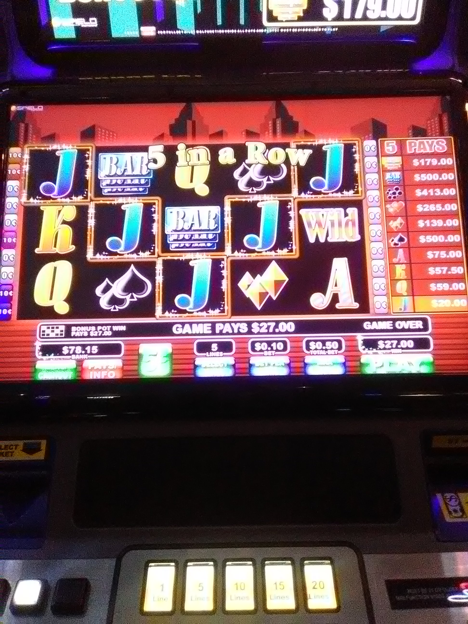 A close-up of a video gaming terminal screen showing a five in a row win and betting controls.