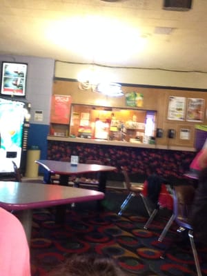 An interior view of a bowling center snack bar and seating area with triangular tables.