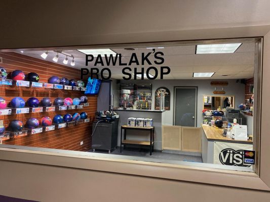 The interior of Pawlak's Pro Shop at Liberty Lanes with bowling balls on display shelves and a service counter.