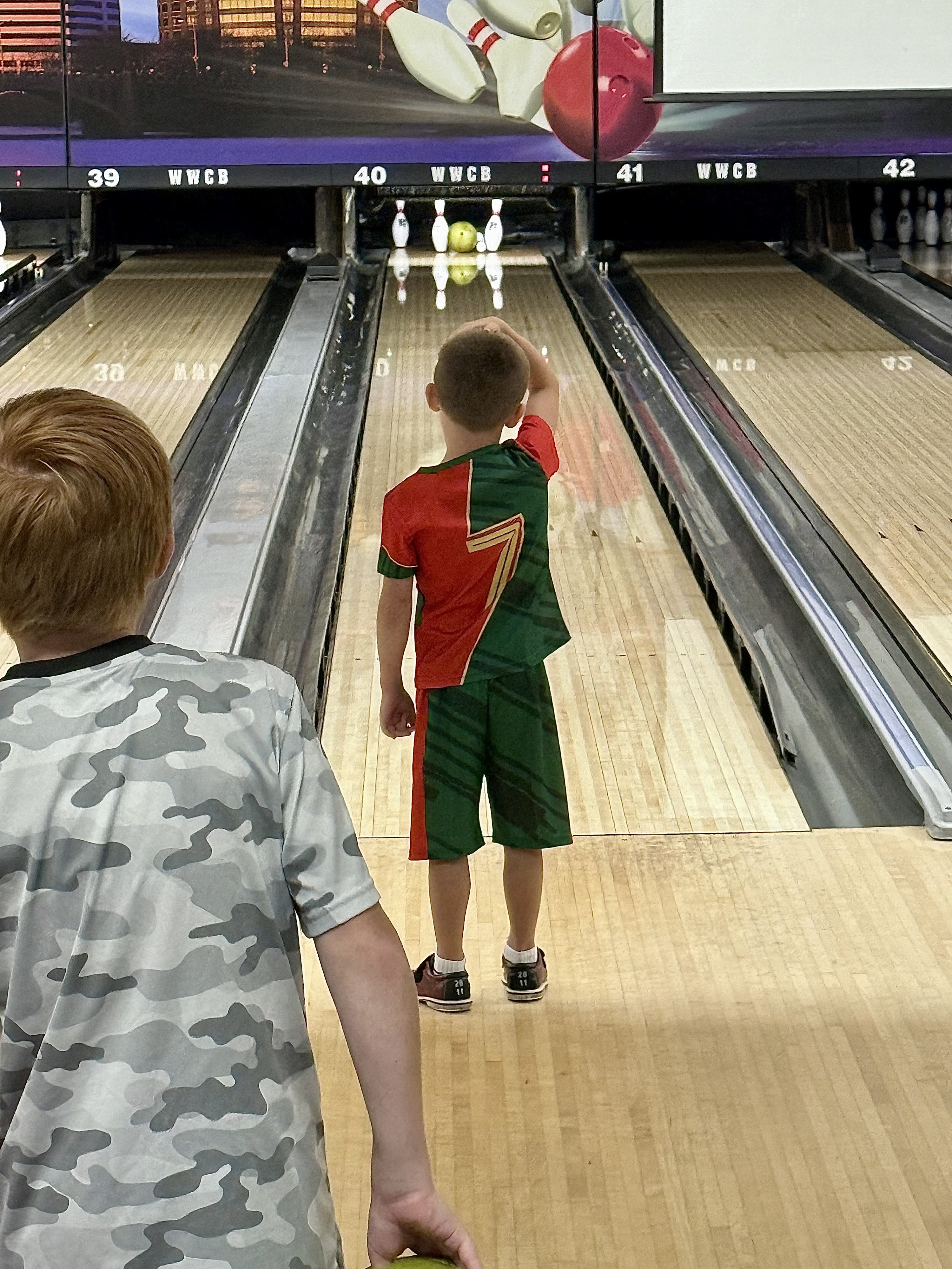 A young boy watches a bowling ball roll down a lane with bumpers at Wayne Webb's Columbus Bowl.