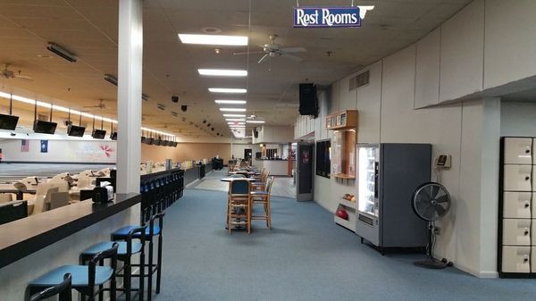 A view of the interior concourse at Little River Lanes featuring high-top seating and bowling lanes.