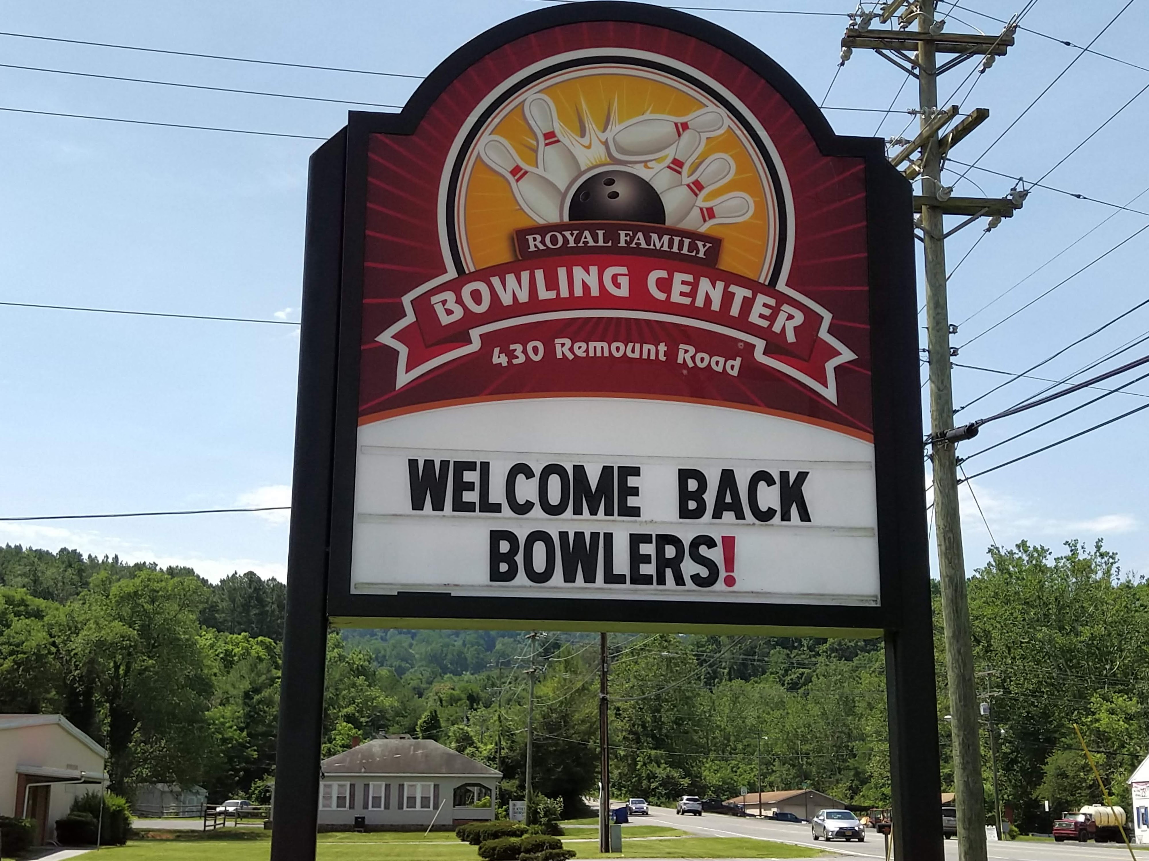 A roadside sign for Royal Family Bowling Center with a welcome message for bowlers.