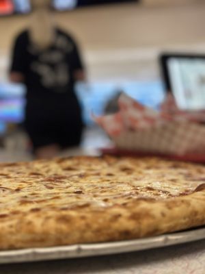 Close-up view of a freshly baked cheese pizza on a metal tray.
