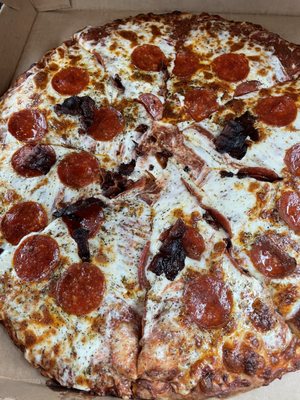 Top-down view of a pepperoni and meat pizza in a cardboard box.