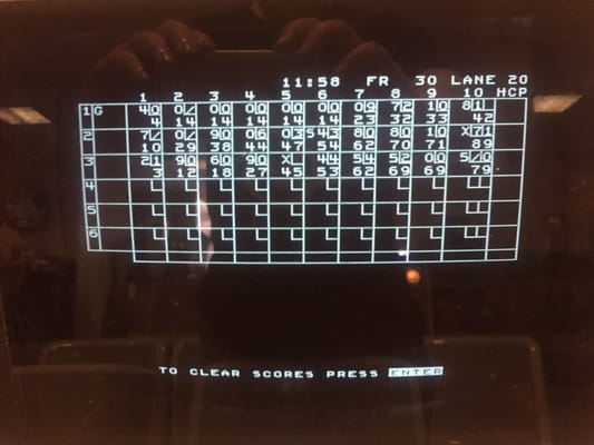 A close-up of a digital bowling score monitor showing three players' frames for Lane 20.