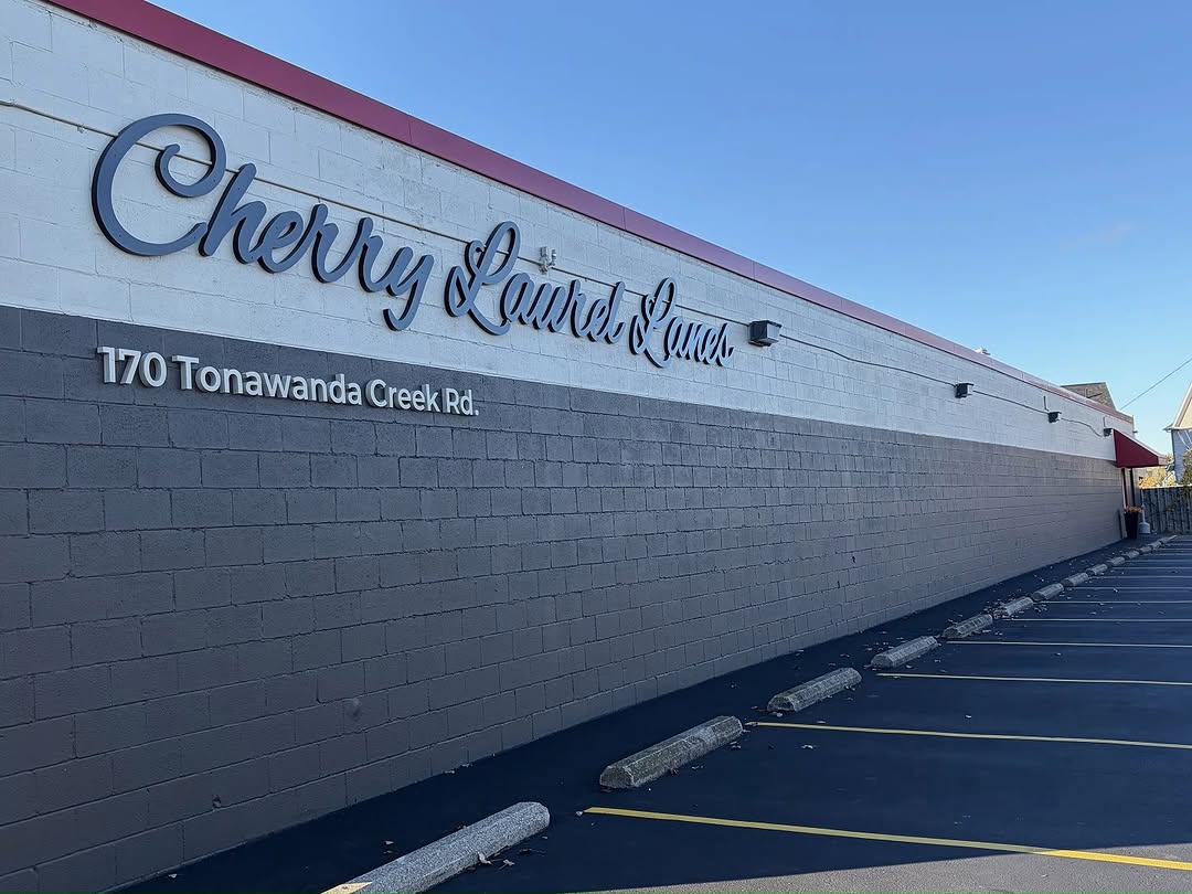 Exterior view of the Cherry Laurel Lanes building and parking lot under a clear blue sky.