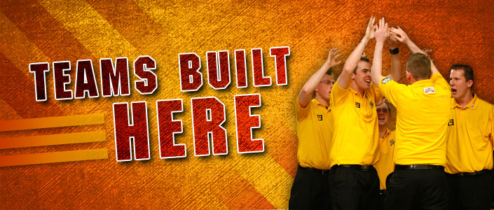 A group of men in matching yellow shirts celebrating next to the words Teams Built Here.