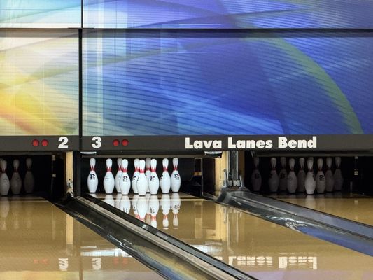 Close-up view of bowling lanes 2 and 3 with the Lava Lanes Bend logo on the masking unit.