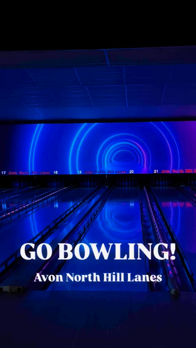 Bowling lanes lit with vibrant blue and purple neon glow lighting with text reading Go Bowling.