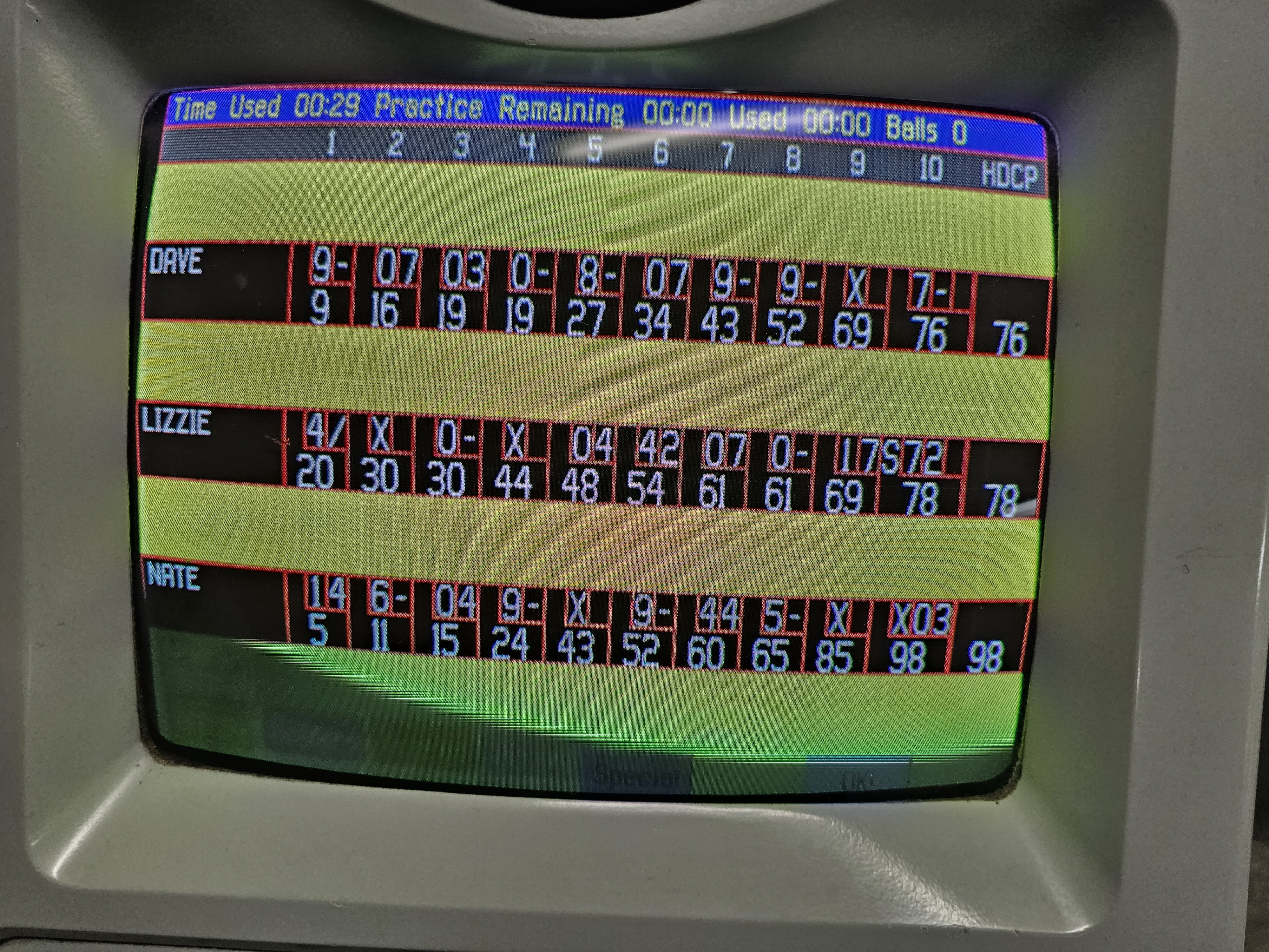 A close-up view of an automatic bowling scoring screen showing game progress for players Dave, Lizzie, and Nate.